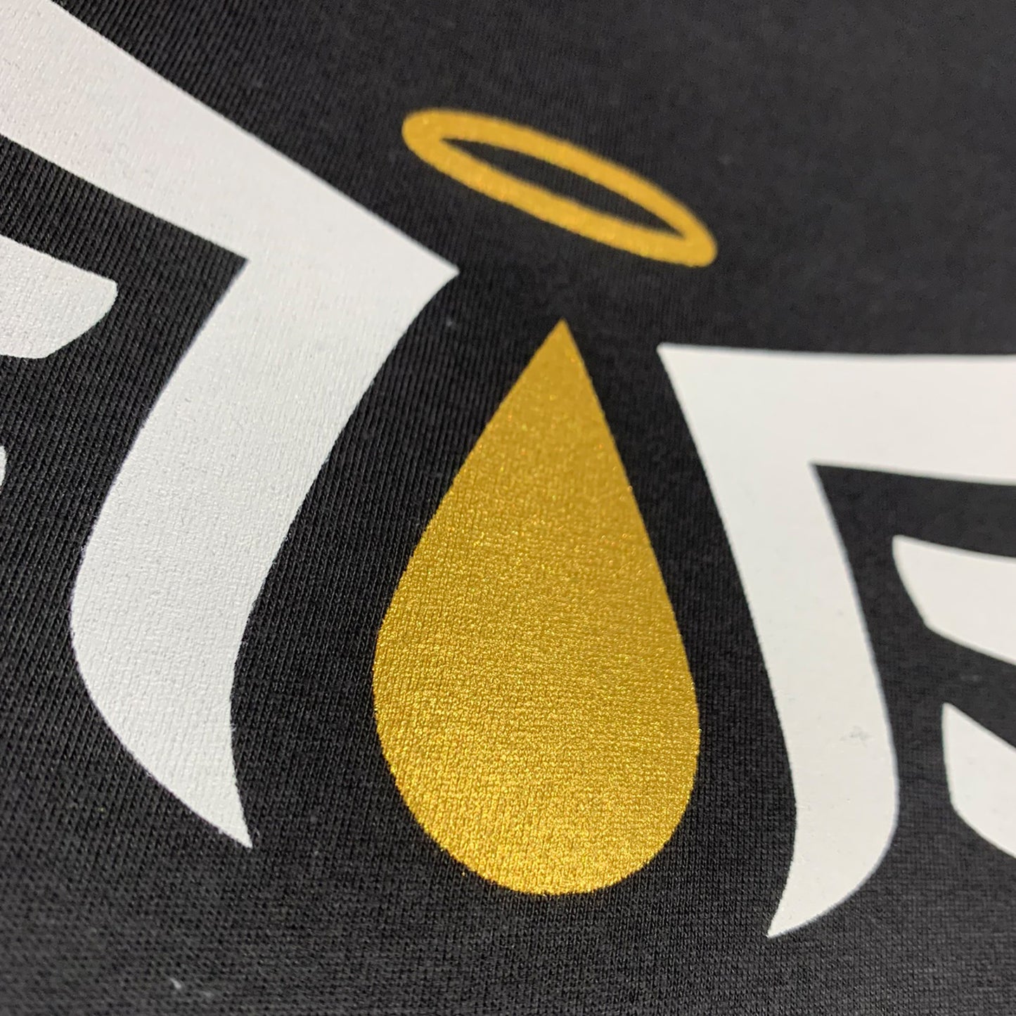 close up picture of angel share tshirt design with gold ink